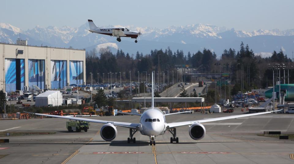 A Boeing 787 taxis as a small plane lands on Monday, March 25, 2013 at Paine Field in Everett. This was the first test flight of a 787 since the fleet was grounded because the danger of a fire with the lithium-Ion battery in the plane. (Associated Press/seattlepi.com, Joshua Trujillo)