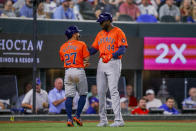 Houston Astros' Jose Altuve (27) and Yordan Alvarez (44) celebrate after scoring on a two-run single from Kyle Tucker during the fourth inning of a baseball game against the Texas Rangers, Monday, April 8, 2024, in Arlington, Texas. (AP Photo/Gareth Patterson)