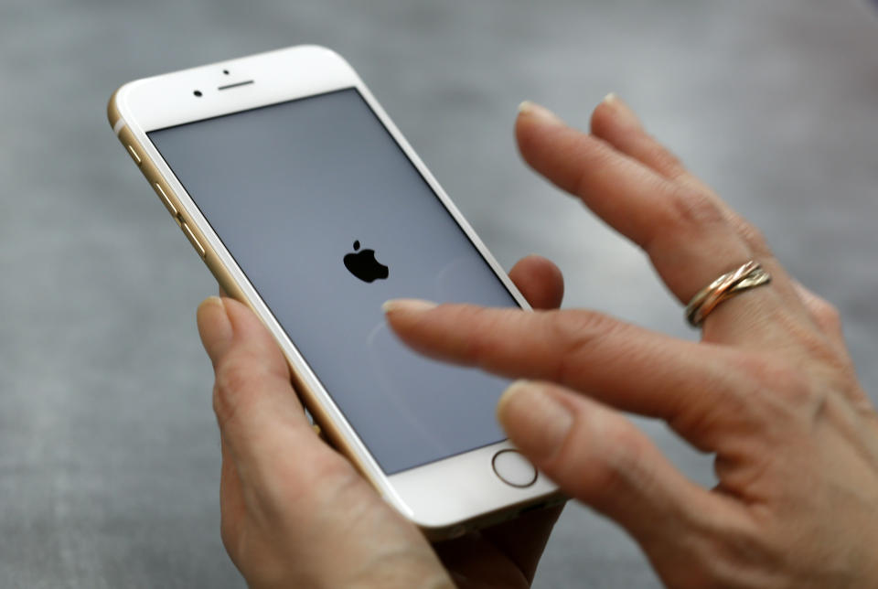 FOTO DE ARCHIVO: Una mujer utiliza su teléfono móvil, un iPhone 6 de Apple en el centro de Múnich, Alemania, 27 de enero de 2016.  REUTERS/Michaela Rehle/File Photo