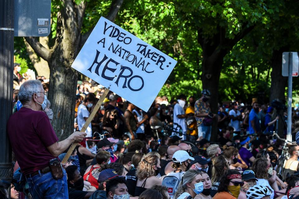 <i>Protesters gather outside the residence of Minnesota Gov. Tim Walz on June 1. One man's sign reads: "Video taker: A national hero."</i>