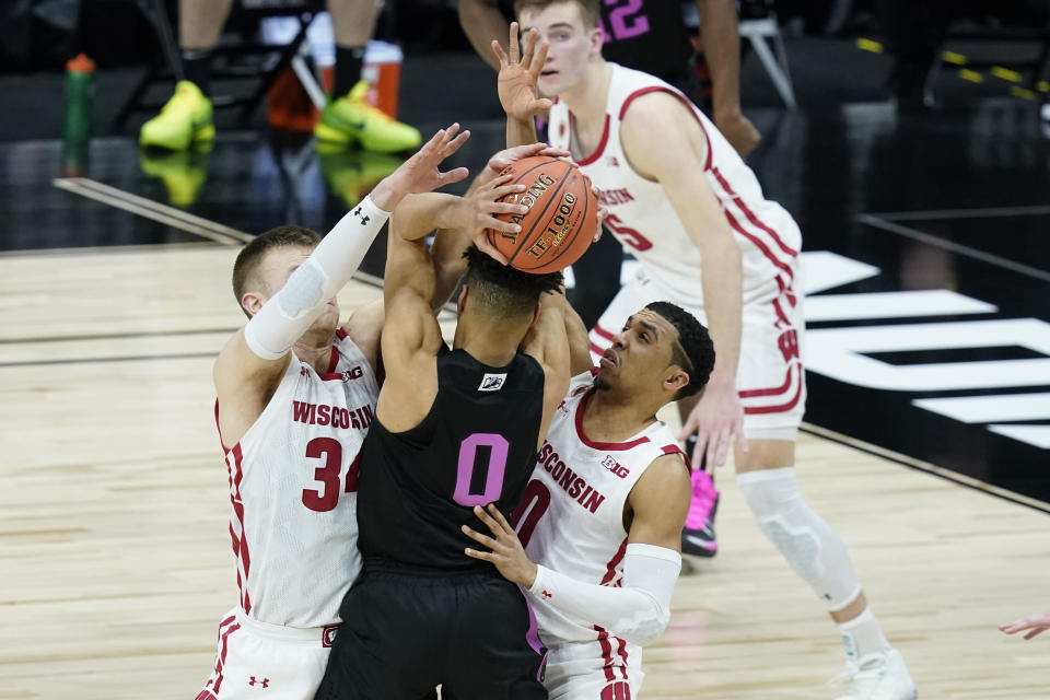 Penn State's Myreon Jones (0) is trapped by Wisconsin's Brad Davison (34) and D'Mitrik Trice (0) during the second half of an NCAA college basketball game at the Big Ten Conference tournament, Thursday, March 11, 2021, in Indianapolis. (AP Photo/Darron Cummings)