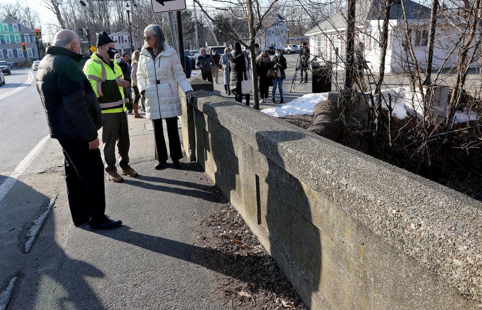 U.S. Rep. Katherine Clark, D-Mass., speaks with Simon Alexandrovich, director of transportation engineering for Framingham, center, and Mayor Charlie Sisitsky about the state’s new funding for bridge repair and upgrades, Jan 24, 2022. Standing by the School Street Bridge over the Cochituate Brook, they discussed funding from the Infrastructure Investment and Jobs Act.