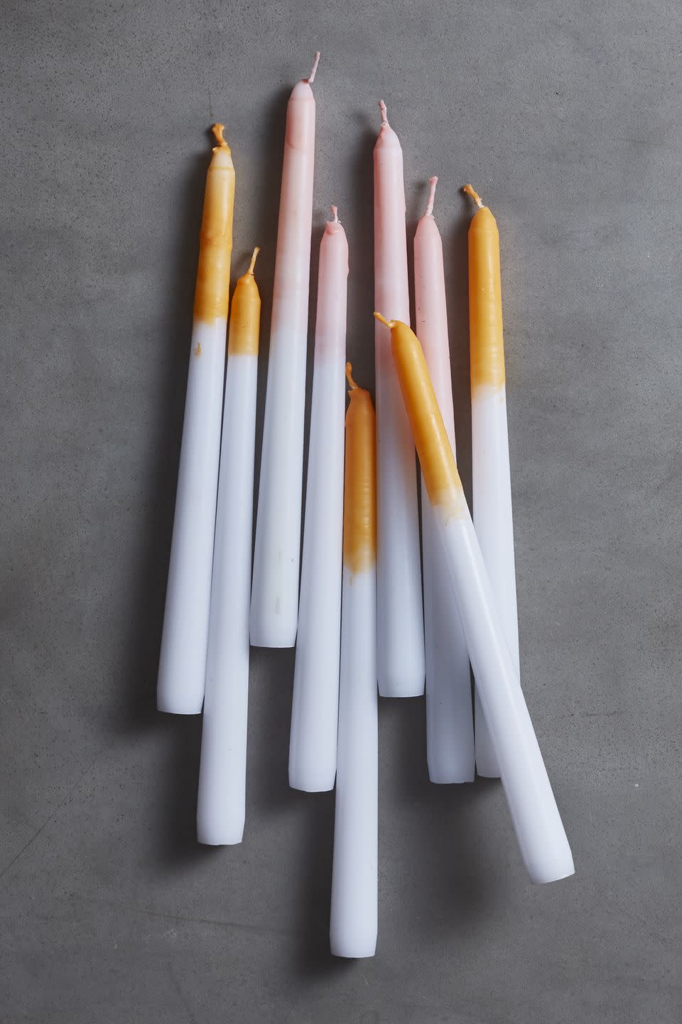 <p>These dip-dyed tapers look pretty enough for year-round use, but <a href="https://www.amazon.com/Crayola-Non-Toxic-Regular-Single-Refill/dp/B0044SAV5S?tag=syn-yahoo-20&ascsubtag=%5Bartid%7C10055.g.1566%5Bsrc%7Cyahoo-us" rel="nofollow noopener" target="_blank" data-ylk="slk:orange crayon;elm:context_link;itc:0;sec:content-canvas" class="link ">orange crayon</a> shavings stirred into melted candle wax can give candles a special Halloween glow. Just dip and let dry. </p><p><a class="link " href="https://www.amazon.com/Natural-Soy-125-415-Wax/dp/B00KMEMB4M/?tag=syn-yahoo-20&ascsubtag=%5Bartid%7C10055.g.1566%5Bsrc%7Cyahoo-us" rel="nofollow noopener" target="_blank" data-ylk="slk:SHOP CANDLE WAX;elm:context_link;itc:0;sec:content-canvas">SHOP CANDLE WAX</a></p>