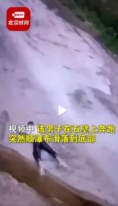 男子於奔跑過程中滑倒，順著瀑布水勢被沖落。（圖／翻攝自時間視頻微博）