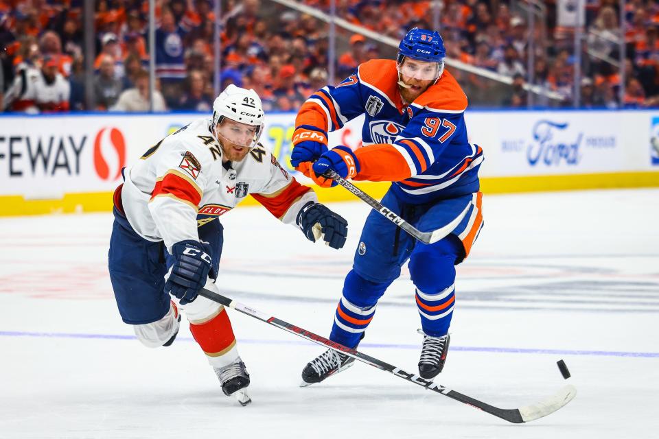 Florida Panthers defenseman Gustav Forsling (42) and Edmonton Oilers center Connor McDavid (97) battles for the puck during the second period in game six of the 2024 Stanley Cup Final at Rogers Place.