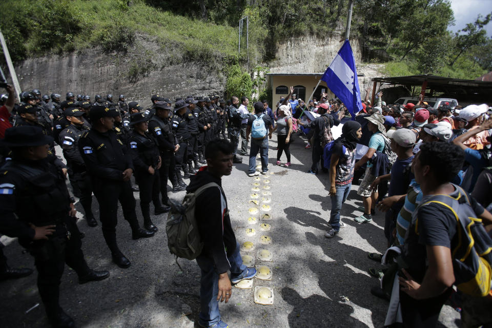 Guatemalan police agents block the border crossing to a Honduran migrant caravan in Agua Caliente, Guatemala, Monday, Oct. 15, 2018. Hundreds Hondurans have joined a caravan of migrants moving toward the country's border with Guatemala in a desperate attempt to flee poverty and seek new lives in the United States. (AP Photo/Moises Castillo)