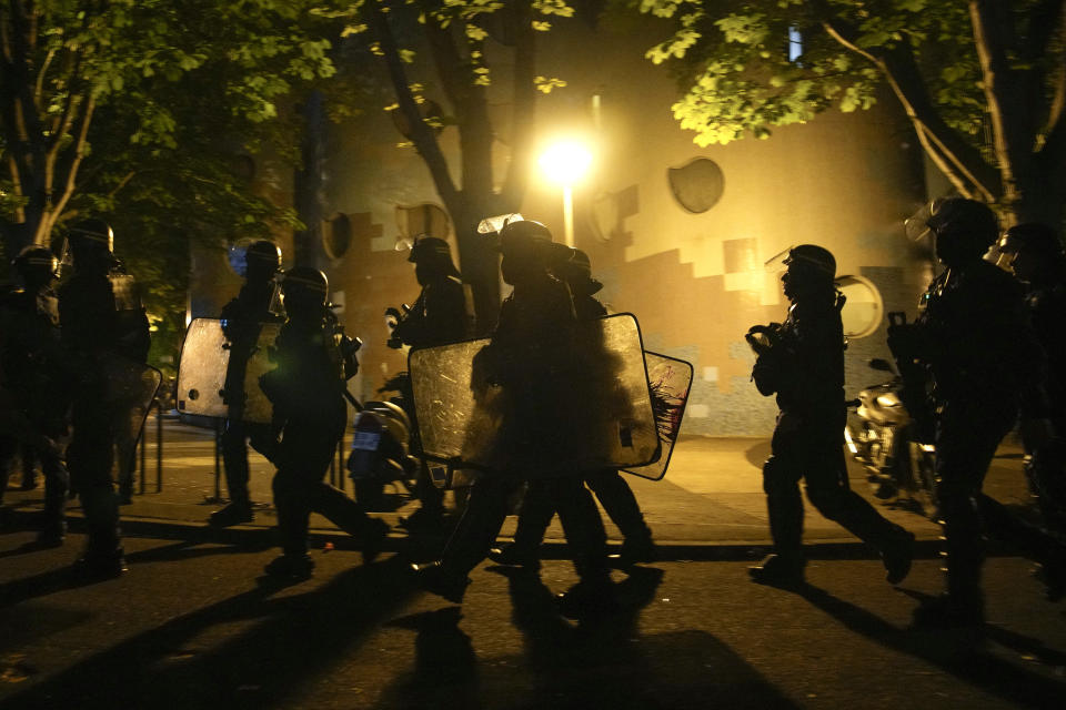 A group of police officers walk during a protest in Nanterre, outside Paris, France, Saturday, July 1, 2023. French President Emmanuel Macron urged parents Friday to keep teenagers at home and proposed restrictions on social media to quell rioting spreading across France over the fatal police shooting of a 17-year-old driver. (AP Photo/Lewis Joly)
