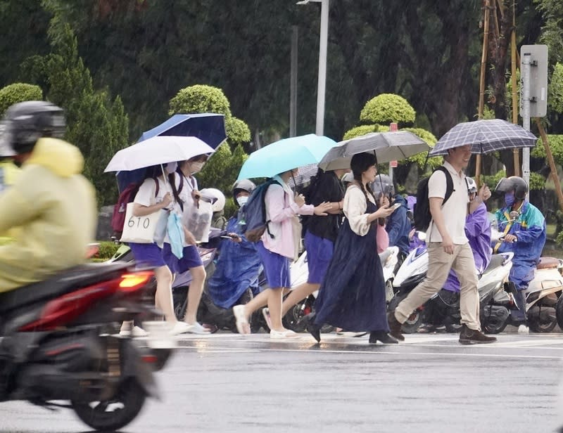 高雄現雨勢  民眾撐傘過馬路（2） 中央氣象署25日下午針對高雄市發布豪雨特報，提醒 民眾留意短延時強降雨；傍晚新興區出現雨勢，民眾 雨中撐傘過馬路。 中央社記者董俊志攝  113年4月25日 