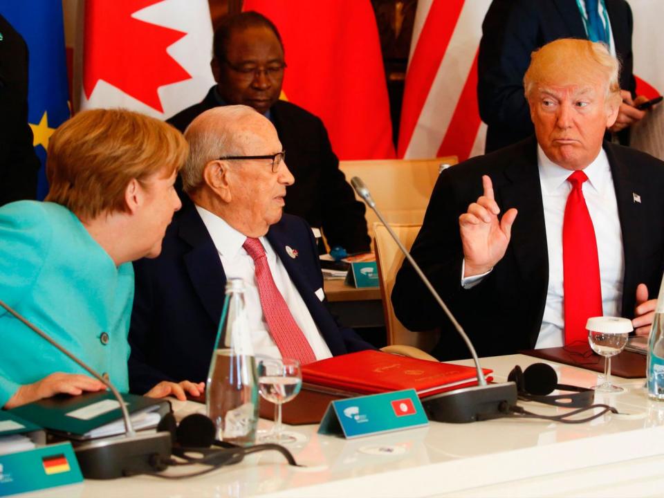 Donald Trump talks to Angela Merkel during the G7; differences emerged from the meeting in Sicily when the US President refused to commit to the Paris climate agreement (AFP)
