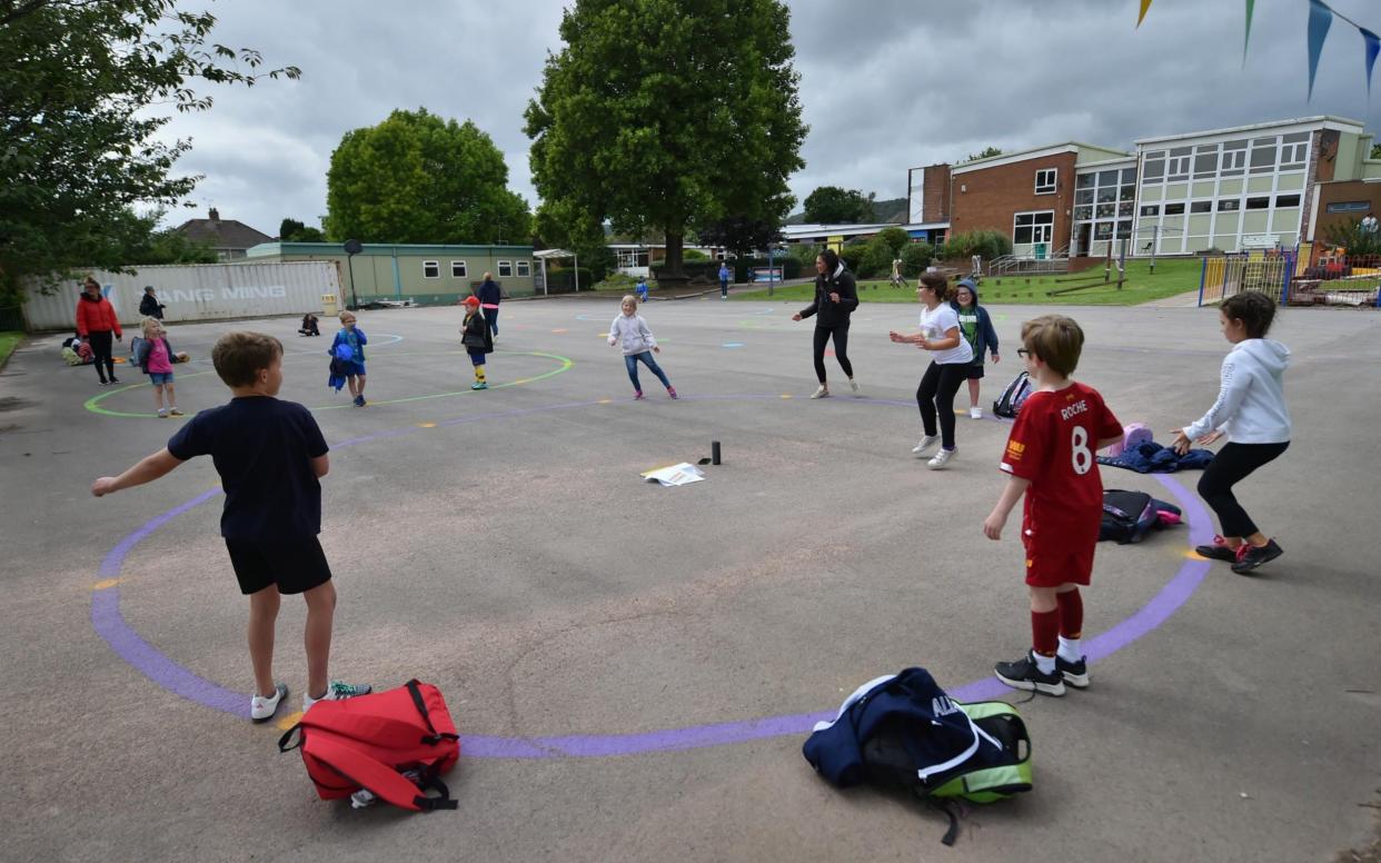 Children dance on a measured and painted socially distanced circle in the playground as they wait to be picked up by their parents at Llanishen Fach Primary School in Cardiff. PA Photo. Picture date: Monday June 29, 2020.Children dance on a measured and painted socially distanced circle in the playground as they wait to be picked up by their parents at Llanishen Fach Primary School in Cardiff. PA Photo. Picture date: Monday June 29, 2020. - PA