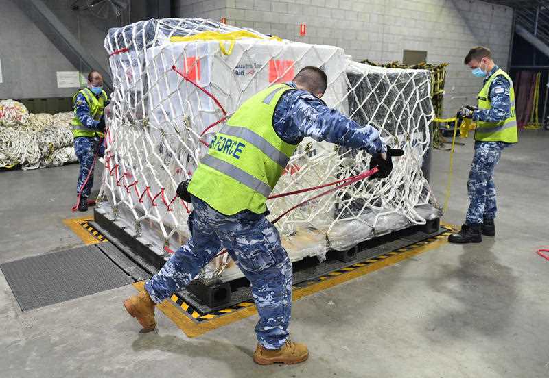 Royal Australian Air Force personal are seen preparing COVID-19 vaccines and humanitarian supplies for loading onto a C-17A Globemaster at RAAF Base Amberley, west of Brisbane.