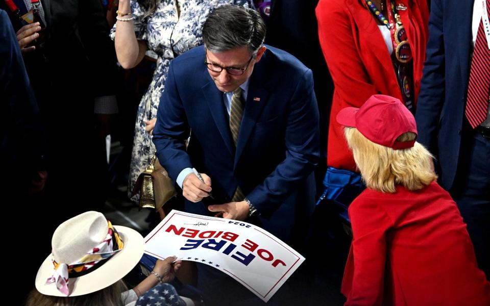 Mike Johnson, the US House Speaker, autographs a 'Fire Joe Biden' sign during the Republican National Convention on Thursday