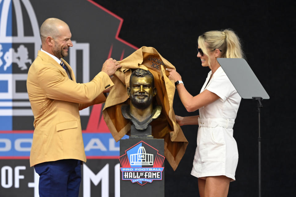 Former NFL player Joe Thomas, left, and his wife Annie unveil his bust during his induction into the Pro Football Hall of Fame in Canton, Ohio, Saturday, Aug. 5, 2023. (AP Photo/David Richard)