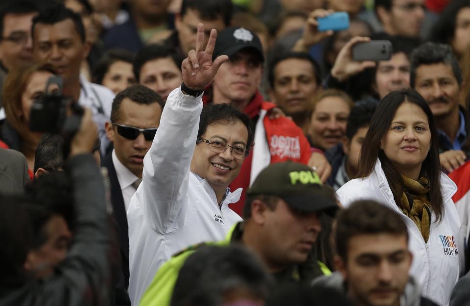 Bogota's mayor Gustavo Petro, center, waves to supporters as he arrives to city hall in Bogota, Colombia, Wednesday, April 23, 2014. Colombia's President Juan Manuel Santos reinstated Petro following a court order. Petro was removed from office in March after President Juan Manuel Santos refused to heed the Inter-American Human Rights Commission's call for a stay on the Inspector General's ouster of the mayor months earlier for alleged administrative missteps. (AP Photo/Fernando Vergara)