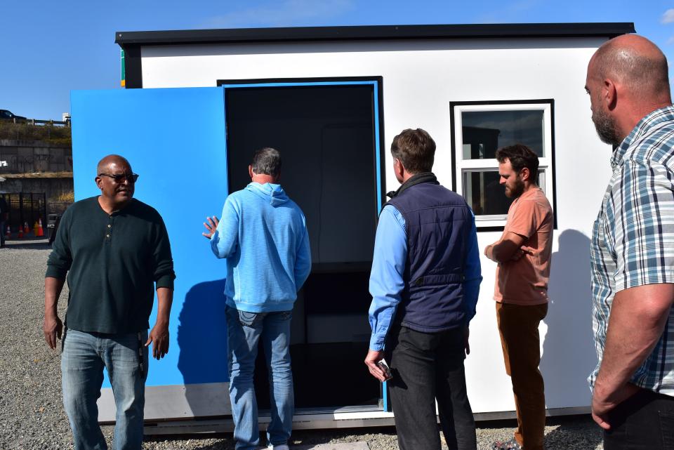 Bremerton mayor Greg Wheeler and Tony Ives of the Kitsap Community Resources take a look into a vacant unit at Palisades Village.