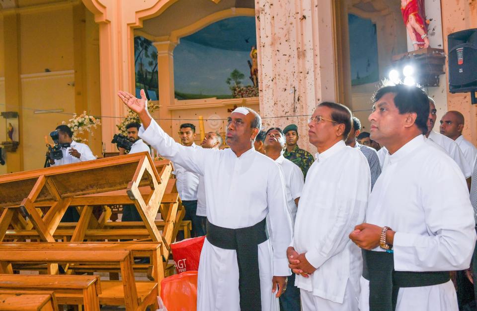 This handout photo taken and released by the Sri Lankan President's Office on April 23, 2019 shows President Maithripala Sirisena  (second from the right), visiting St. Sebastian's church in Negombo, two days after a series of bomb attacks targeting churches and luxury hotels in Sri Lanka.