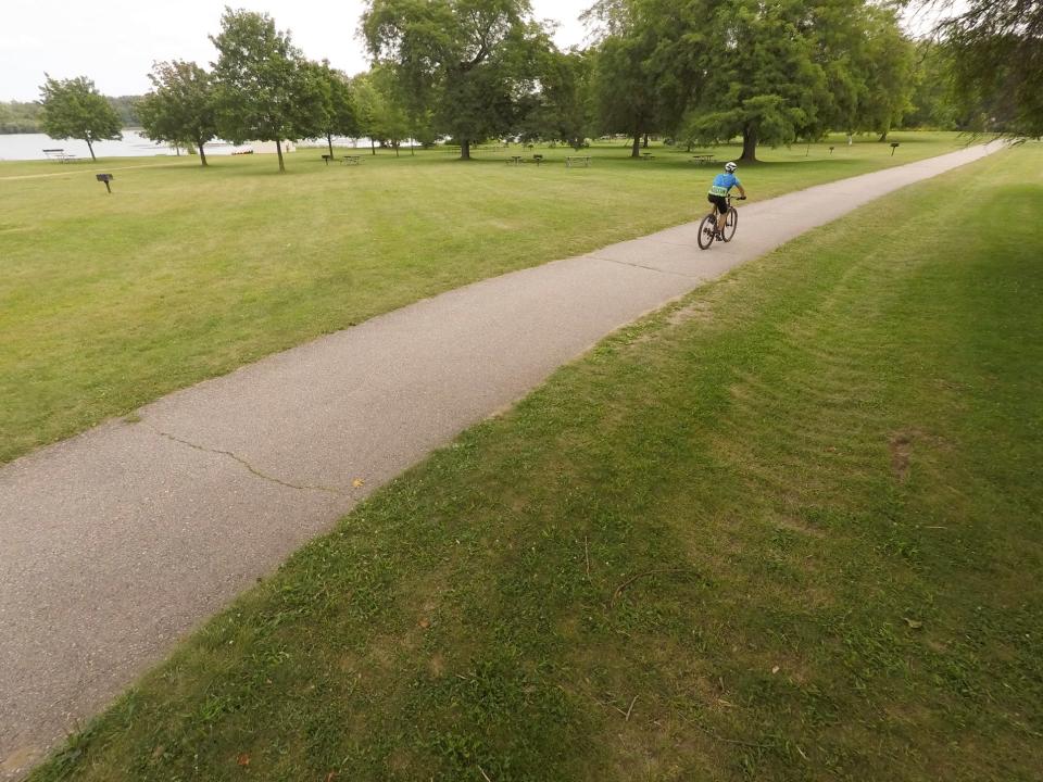 A cyclist rides a hike and ski trail at the Island Lake State Recreation Area.