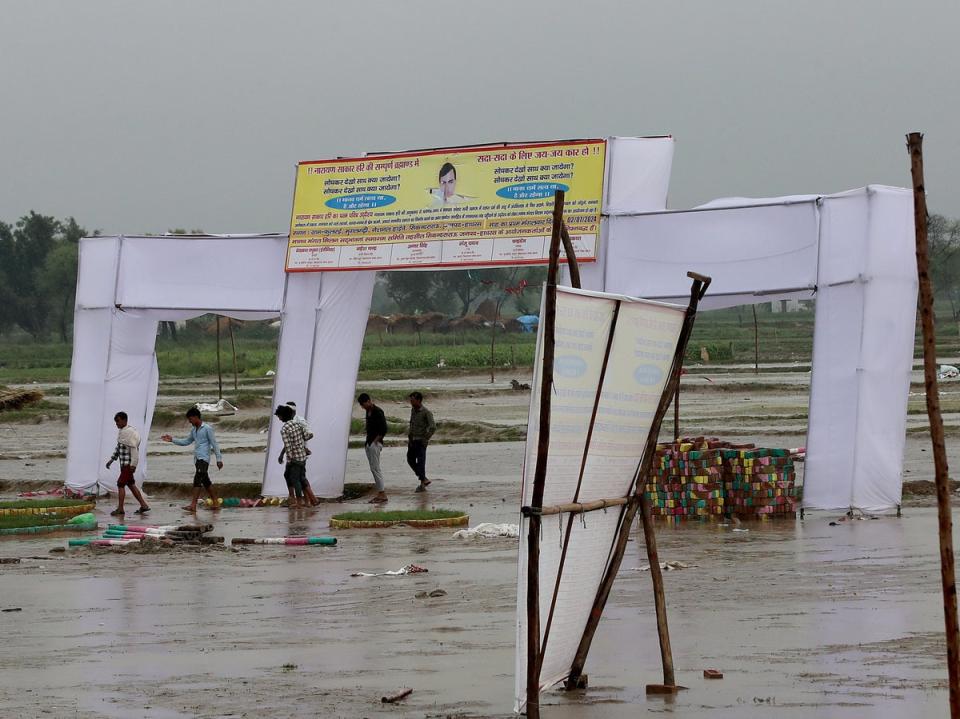 People walk at the scene after a stampede in Hathras, Uttar Pradesh (EPA)