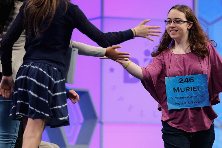 Muriel Margaret Cotman of Victoria, Texas, high-fives competitors as she leaves the stage after misspelling her word during the 88th Scripps National Spelling Bee semifinals at the Gaylord National Convention Center May 28, 2015 in Washington, DC