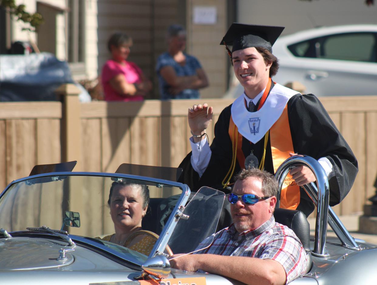 Cheboygan senior Blaine Baldwin waves to the crowd during Friday's senior parade.