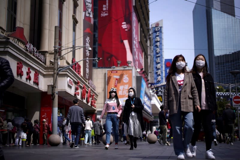 People wear masks at a main shopping area after the city's emergency alert level for coronavirus disease (COVID-19) was downgraded, in Shanghai