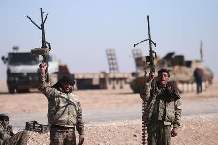 Syrian Democratic Forces (SDF) fighters hold up their weapons in the north of Raqqa city, Syria February 3, 2017. Picture taken February 3, 2017. REUTERS/Rodi Said