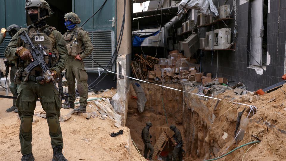 Israeli soldiers stand near the opening to a tunnel in Gaza City on November 22. - Ronen Zvulun/Reuters