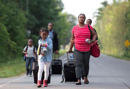 FILE PHOTO: A family that stated they are from Haiti walk to the US-Canada border to cross into Canada from Champlain, New York, U.S. August 11, 2017. REUTERS/Christinne Muschi/File Photo