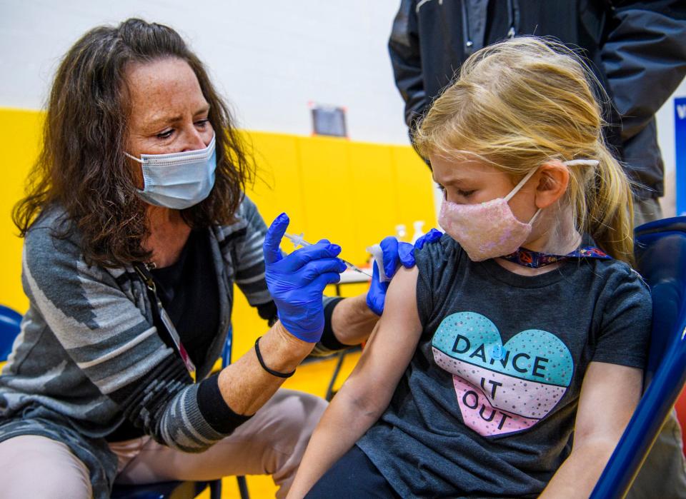 A young girl gets her COVID-19 vaccine shot from a nurse at Edgewood Primary School in Indiana.