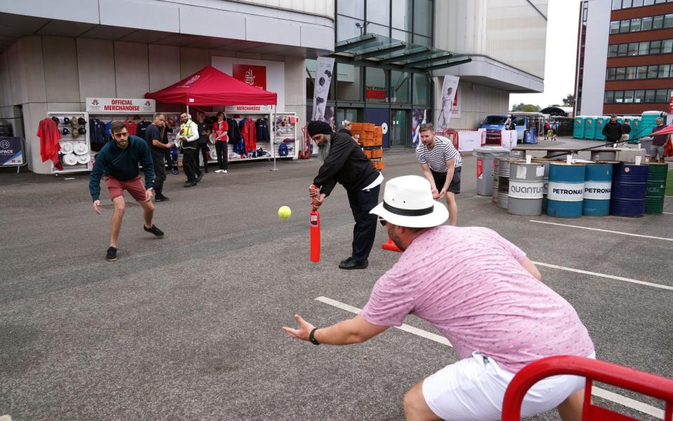 Cricket fans play cricket outside of the Emirates Old Trafford in Manchester after India forfeited the fifth Test against England over Covid concerns, the England and Wales Cricket Board has announced - PA