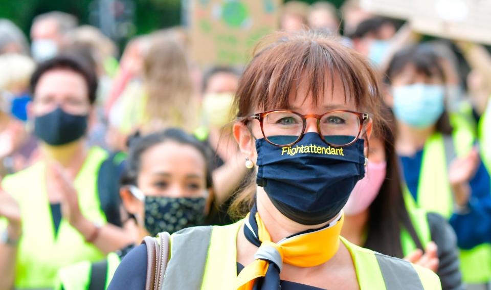 A flight attendant wears a face mask as employees of German flight operator Lufthansa demonstrate on June 24, 2020 in Berlin, in order to call on investors to back a bailout plan hammered out to rescue the airline hit by the coronavirus crisis. (Photo by TOBIAS SCHWARZ/AFP via Getty Images)