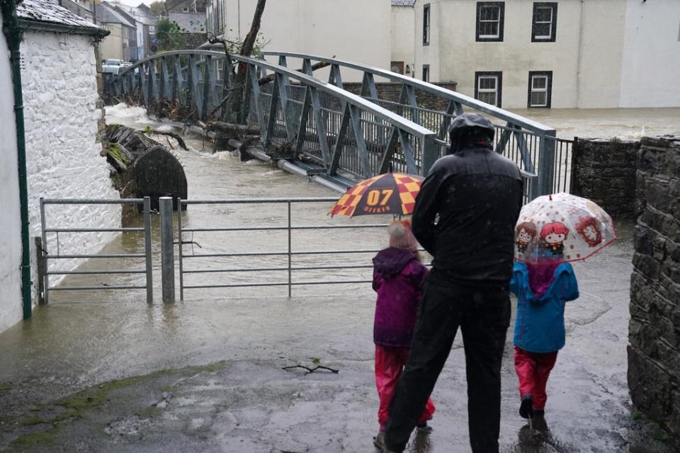 Brollies were out in force for those watching the rising water levels (Owen Humphreys/PA) (PA Wire)