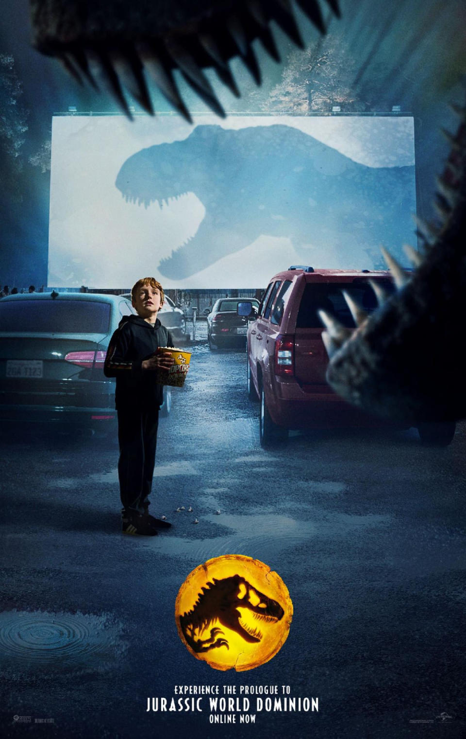 A small boy looks at a T.rex as the dinosaur's shadow is seen on the blank drive-in movie theater screen in Colin Trevorrow's Jurassic World: Dominion prologue short