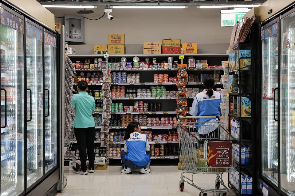 Staff stock canned food at a supermarket ahead of Typhoon Krathon which is expected to intensify and make an unusual landfall (REUTERS)