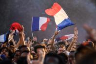 <p>People cheer and wave French flags as they gather at a fan zone in Paris on July 10, 2018 to watch the Russia 2018 World Cup semi-final football match between France and Belgium. (Photo by Eric FEFERBERG / AFP) </p>