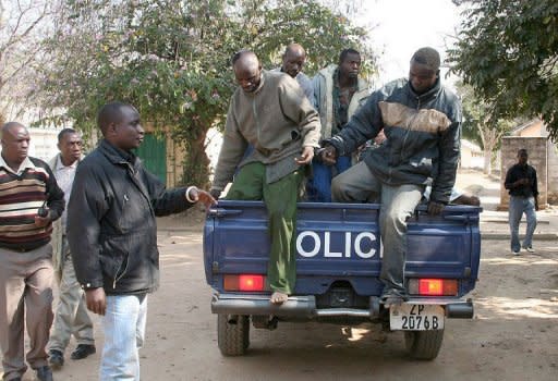 Zambian miners arrested over the death of a Chinese manager in a wage riot at a Chinese-owned coal mine, are escorted by Zambian police into a holding cell at Choma Magistrate Court in Sinazongwe on August 8, 2012. Zambia arrested 12 people over the death of the Chinese manager at the coal mine known for sometimes violent tensions with workers