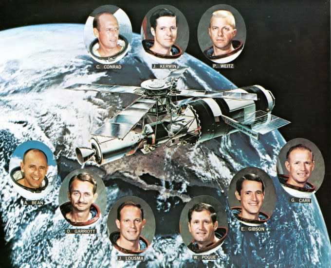 Illustration of the Skylab orbiting space station, surrounded by portraits of astronauts from the three manned missions to the station, 1974. Pictured are, top row, from left, Skylab 2 astronauts Charles 'Pete' Conrad Jr., Joseph Kerwin, Paul Weitz. bottom row, from left, Skylab 3 astronauts Alan Bean, Owen Garriott, and Jack Lousma, and Skylab 4 astronauts William Pogue, Edward Gibson, and Gerald Carr.