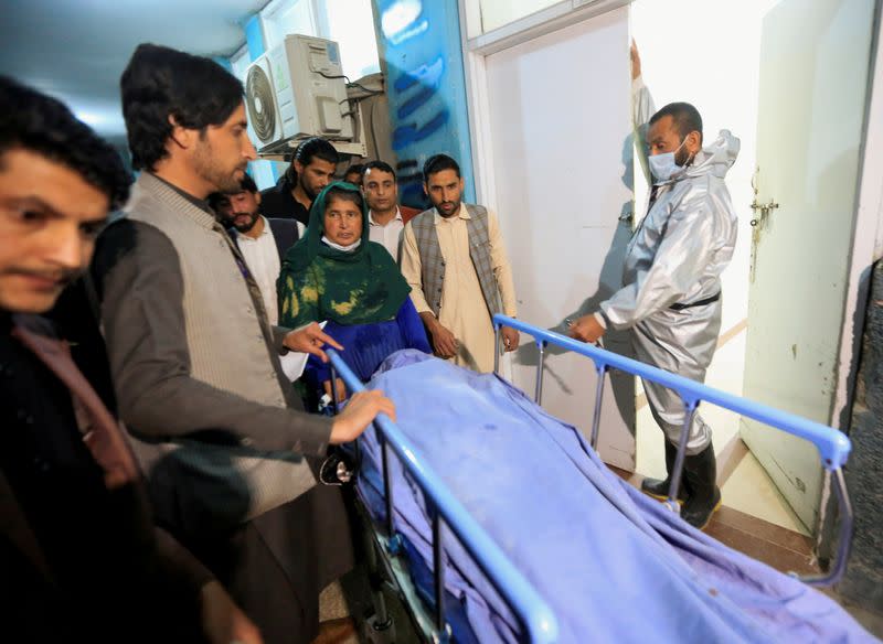 FILE PHOTO: Afghan men transport the body of one of three female media workers who were shot and killed by an unknown gunmen, at a hospital in Jalalabad