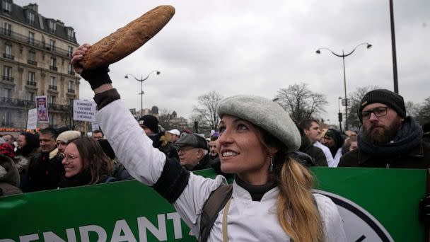 PHOTO: A baker clutches a baguette during a demonstration Monday, Jan. 23, 2023, in Paris. (Michel Euler/AP)