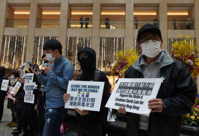 武漢肺炎疫情肆虐，每日有大量中國旅客進入的香港至今未能全面封關，多位香港民眾手持標語抗議。（美聯社）