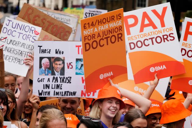 Demonstrators hold banners during a junior doctors rally outside Downing Street in London, Friday, Aug. 11, 2023.