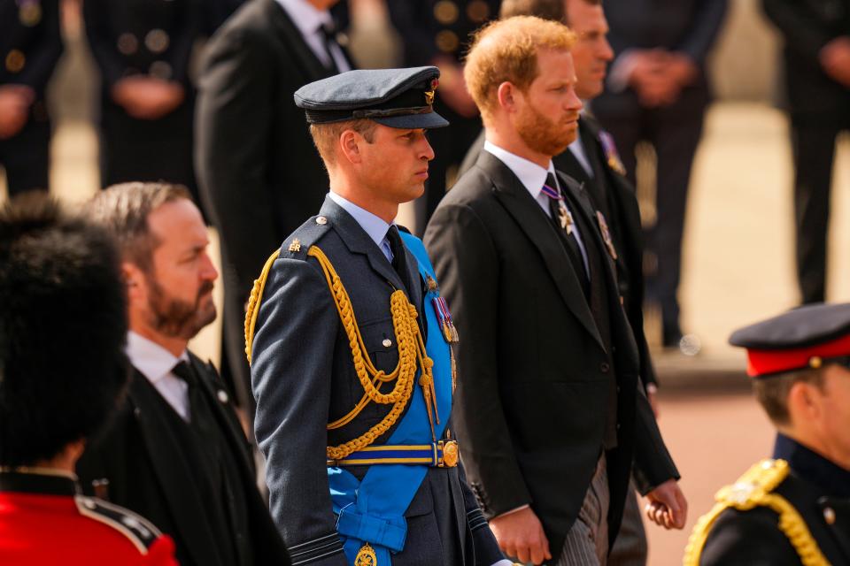 Prince William, center, and Prince Harry, right, follow the coffin of Queen Elizabeth II as it is pulled following her funeral service in Westminster Abbey in London on Sept. 19, 2022.