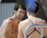 Michael Phelps talks with a fellow swimmer after practice, Wednesday, April 23, 2014, in Mesa, Ariz. Phelps is competing in the Arena Grand Prix at Mesa, as he returns to competitive swimming after a nearly two-year retirement. (AP Photo/Matt York)