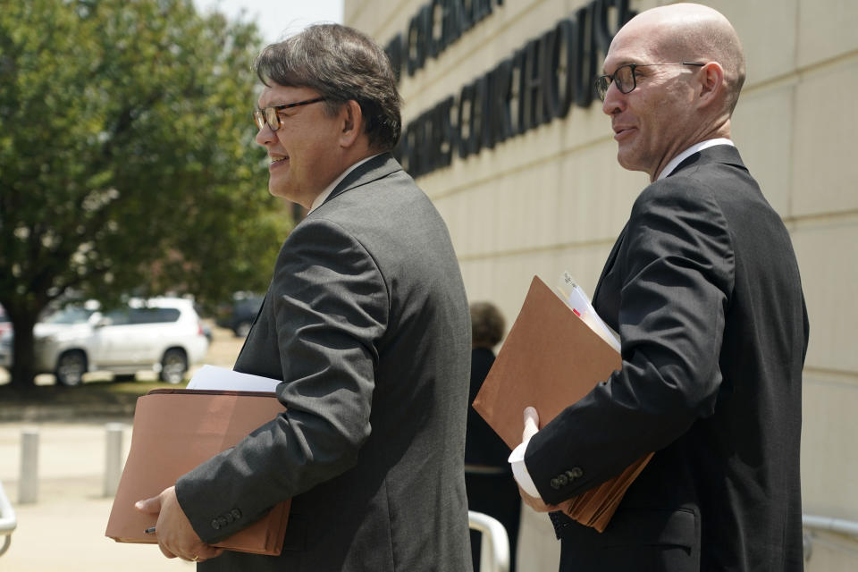 Attorneys Gerald Kucia, left, and Rex Shannon, both with the Mississippi Attorney General's Office, exit the Thad Cochran United States Courthouse in Jackson, Miss., Monday, May 22, 2023, for a lunch break, during the first day in federal court where a judge is hearing arguments about a Mississippi law that would create a court system with judges who would be appointed rather than elected. (AP Photo/Rogelio V. Solis)