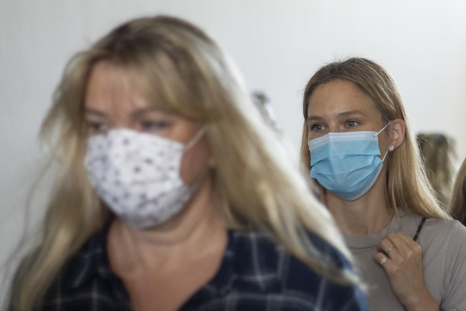 Israeli top model Bar Refaeli, right, and her mother, Zipi Rafaieli wear face masks amid the coronavirus pandemic as they leave a courtroom in Tel Aviv, Israel, Sunday, Sept. 13, 2020. The Israeli court sentenced Bar Refaeli to nine months of community service and her mother was sentenced to 16 months in prison, ending a prolonged tax evasion case that had sullied the image of a once beloved national icon. (AP Photo/Ariel Schalit, Pool)