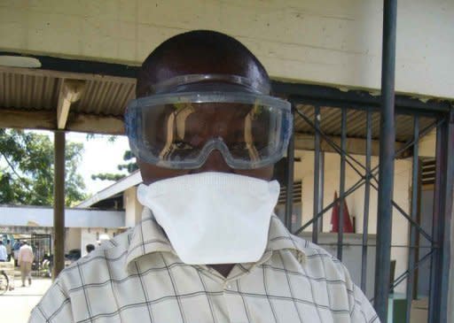 A Ugandan health official wears protective gear as he deals with an ebola outbreak at the Bityo hospital in 2007. Uganda's president has warned against shaking hands and other physical contact after the first reported death from the deadly Ebola virus in the capital Kampala