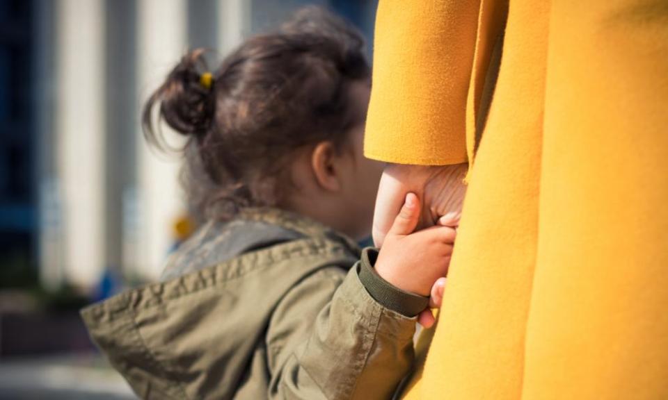 Child holding woman's hand