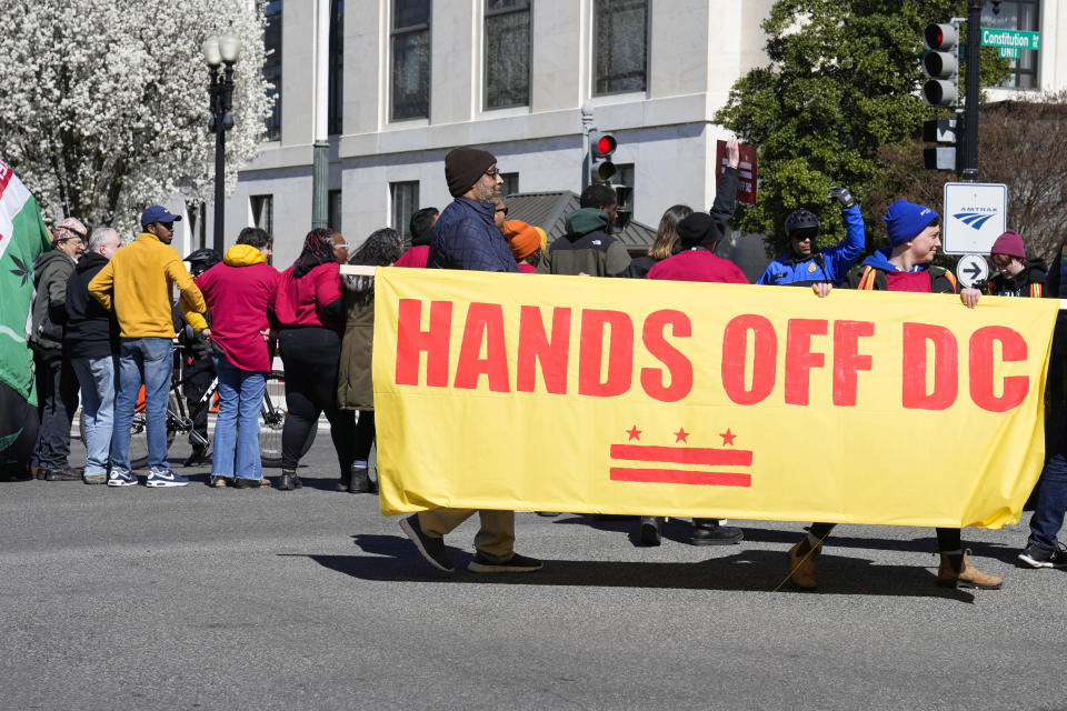 Demonstrators hold a banner during a protest in front of the Dirksen Senate Office Building, Wednesday, March 8, 2023, on Capitol Hill in Washington. Protestors rallied against a Republican-sponsored resolution blocking new District of Columbia laws that would overhaul how the nation's capital prosecutes and punishes crime. (AP Photo/Mariam Zuhaib)