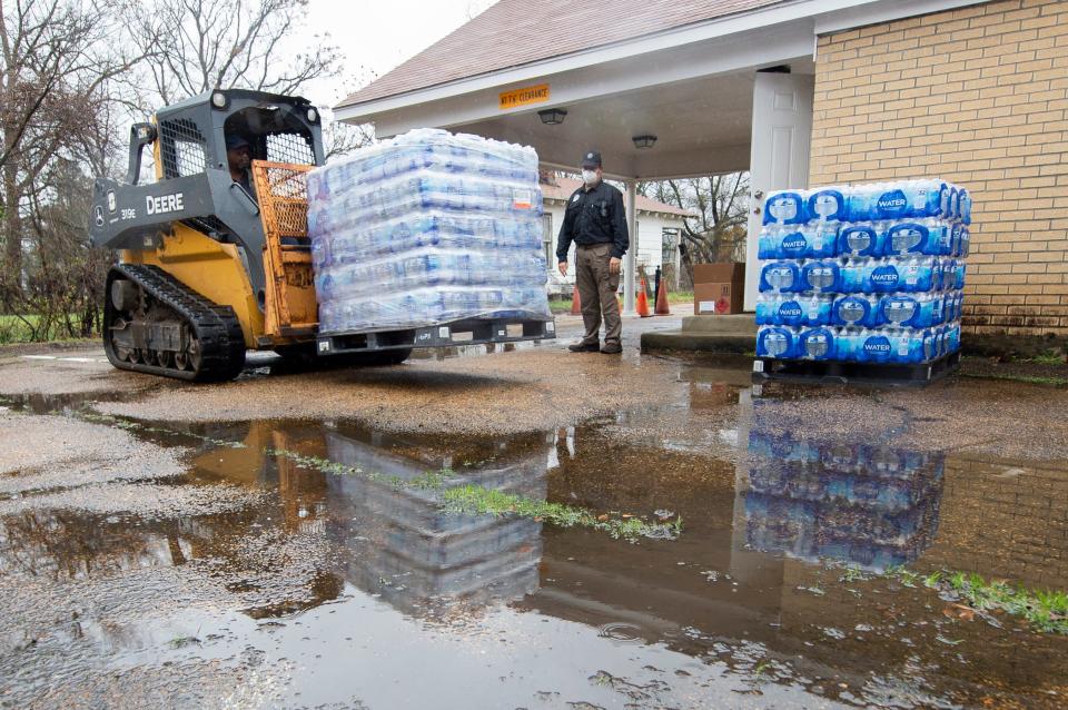 David Battaly, center, with MEMA, watches the delivery of pallets of bottled water at New Mount Zion Missionary Baptist Church on Maple Street shortly after noon Monday, March 1, 2021. MEMA, Mississippi Army National Guard and members of New Mount Zion Missionary Baptist Church manning the site, with publicized hours of operation beginning at 10 a.m., could offer hand sanitizer, face masks and non-potable water but no bottled water before the delivery. There were three pallets of water delivered for distribution.