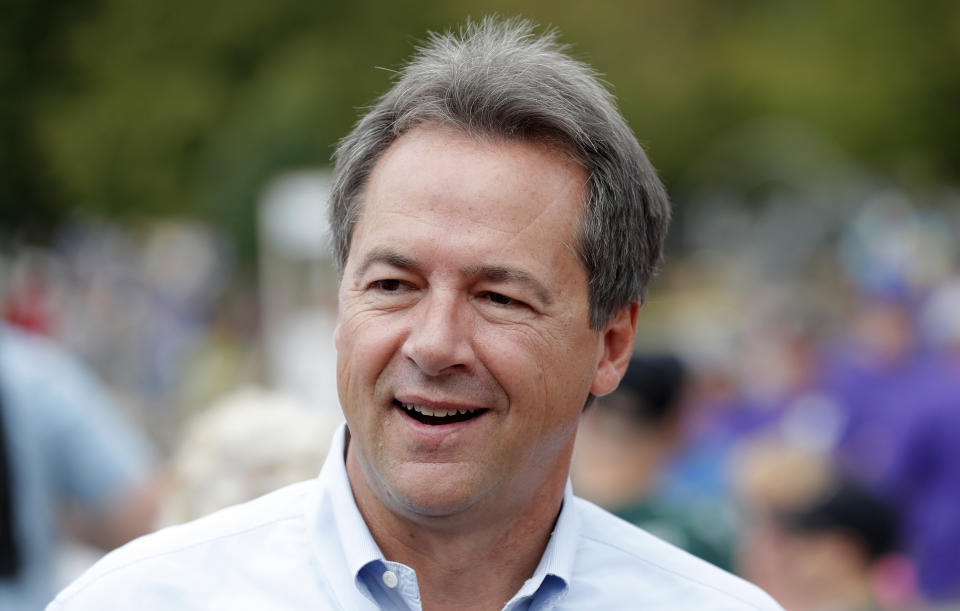 FILE - In this Aug. 16, 2018, file photo, Montana Gov. Steve Bullock walks down the main concourse during a visit to the Iowa State Fair in Des Moines, Iowa. Former Vice President Joe Biden and several nationally known senators are commanding most of the attention in Democrats’ early presidential angling, but there are several governors and mayors, including Bullock, eyeing 2020 campaigns, as well. (AP Photo/Charlie Neibergall, File)